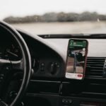 Smartphone mounted in a car phone holder showing navigation