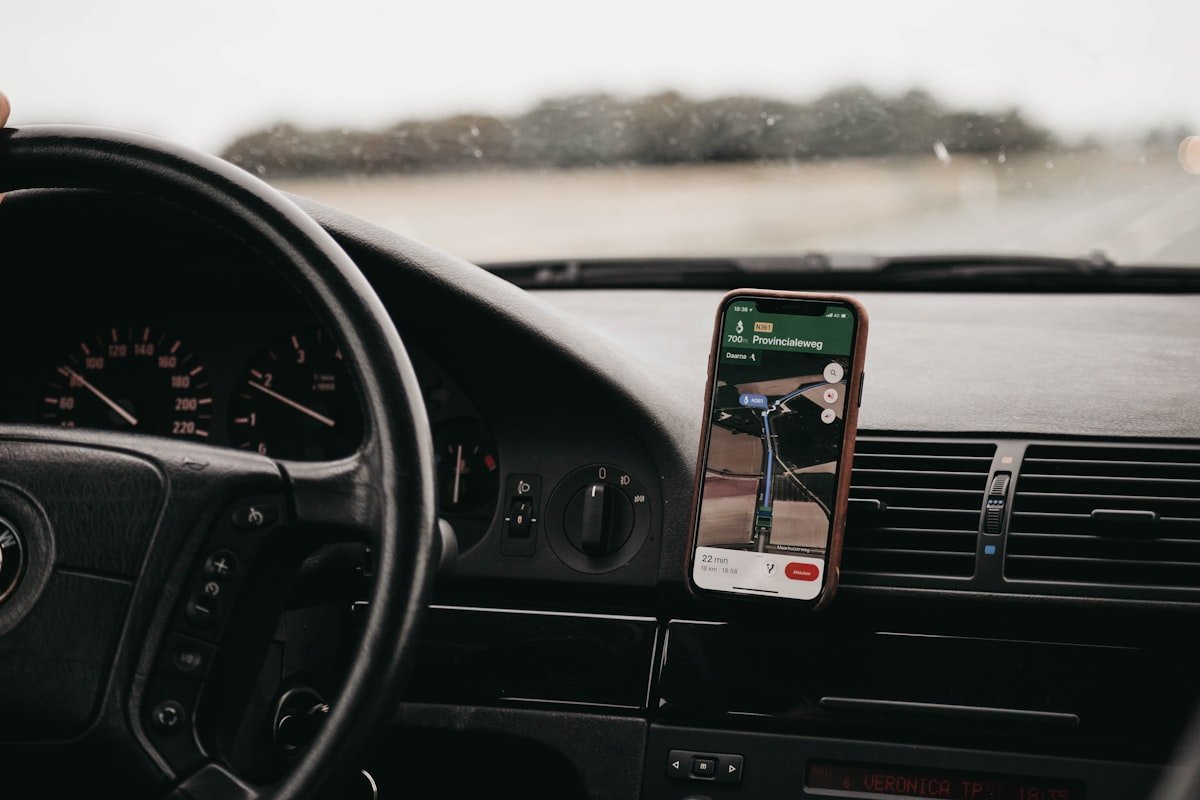 Smartphone mounted in a car phone holder showing navigation